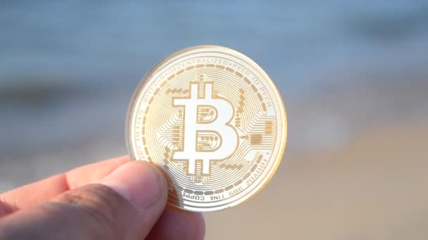 Man Met Een Bitcoin Btc Munt Hand Achtergrond Zeegolven Zandstrand — Stockvideo