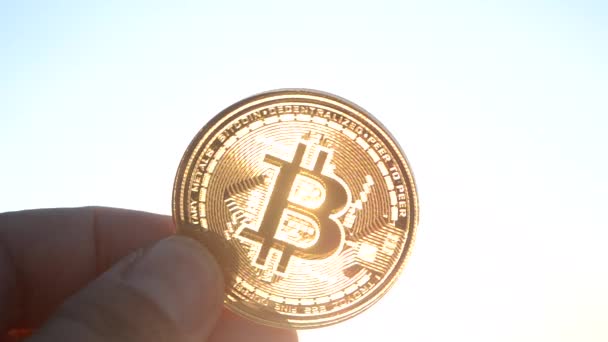 Persoon Met Een Bitcoin Btc Munt Zijn Hand Tegen Achtergrond — Stockvideo