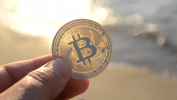 Muž Drží Jeden Bitcoin Btc Mince Ruce Pozadí Mořské Vlny — Stock video