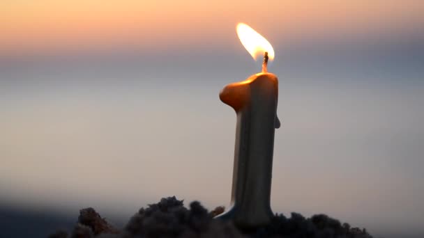 日落时分 在靠近海浪水面的海滨沙滩上 燃烧着形状为第1号的石蜡蜡烛 庆祝浪漫假期的新年庆祝会 — 图库视频影像