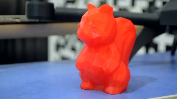 红色模型用蓝色表面融化的塑料打印在3D打印机上 桌上的3D打印机打印的红色物体 新概念现代创新印刷技术 — 图库视频影像