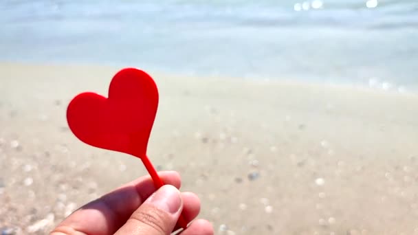Persona Sosteniendo Los Dedos Mano Palo Forma Corazón Rojo Playa — Vídeos de Stock