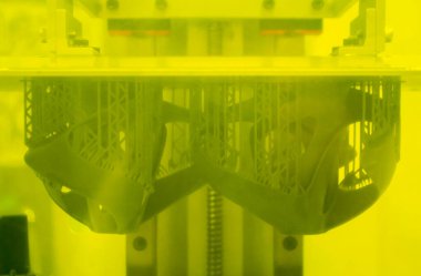 3D yazıcıda yakın plan baskı modelleri. 3D yazıcının içindeki baskı platformunda sıvı fotopolimer reçinelerden fotopolimer sla 3D yazıcıya basılan nesneler. Modern yenilikçi katkı teknolojisi.