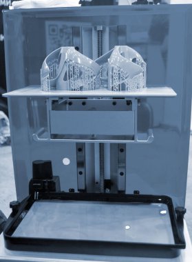 3D yazıcıda yakın plan baskı modelleri. 3D yazıcının içindeki baskı platformunda sıvı fotopolimer reçinelerden fotopolimer sla 3D yazıcıya basılan nesneler. Modern yenilikçi katkı teknolojisi.