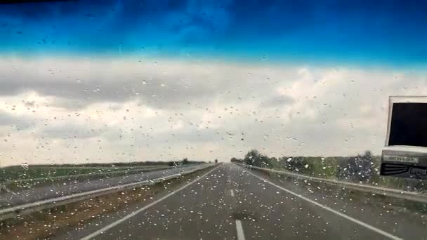 자동차를 운전하는 내리는 내리는 바람막이를 도로의 비오는 날씨에 아스팔트 도로에 — 비디오