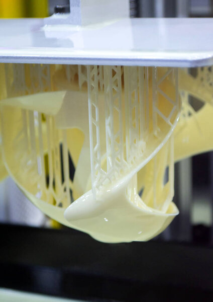 Printed models on 3D printer close-up. Objects printed on photopolymer sla 3D printer from liquid photopolymer resins on printing platform. Modern progressive additive technology. 3D printer printing