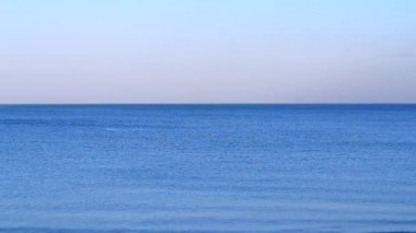 Sakin ol. Denizde sakin ol. Dalgalar olmadan mavi denizin pürüzsüz yüzeyi ve sakin rüzgarsız bir yaz akşamında mavi gökyüzü. Sakin havada soyut deniz manzarası. Doğal arka plan. Doğa zemin.