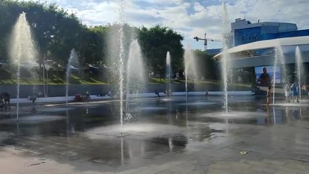 2023年7月2日 オデッサ ウクライナ 晴れた夏の日に歩行者の地上噴水から水のジェットの下で走る子供たち 大きな公共の街の噴水と街の広場に子供を飛ばす — ストック動画