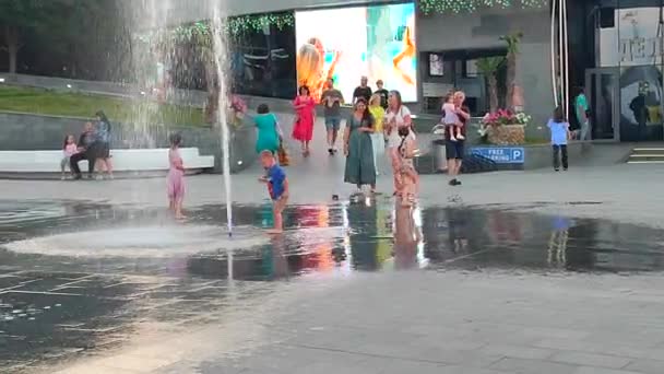 敖德萨 乌克兰 Odessa Ukraine 2023年7月2日 在阳光灿烂的夏日 孩子们在从行人地面喷泉喷出的水柱下奔跑 城市的大型公共街道喷泉和广场上飞溅的儿童 — 图库视频影像