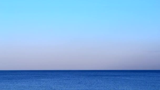 冷静に 海に沈む 夏の夕方に穏やかな風のない天候で波と青空のない青い海の滑らかな表面 静かな天気の中で抽象的な海の景色 自然の背景 自然の背景 — ストック動画