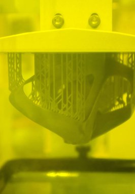 3D yazıcıda yakın plan baskı modelleri. 3D yazıcının içindeki baskı platformunda sıvı fotopolimer reçinelerden fotopolimer sla 3D yazıcıya basılan nesneler. Modern yenilikçi katkı teknolojisi.