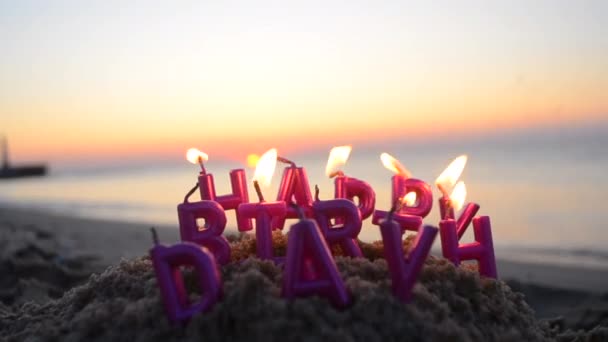 Свечи Форме Букв Днем Рождения Розовом Цвете Горят Песчаном Пляже — стоковое видео
