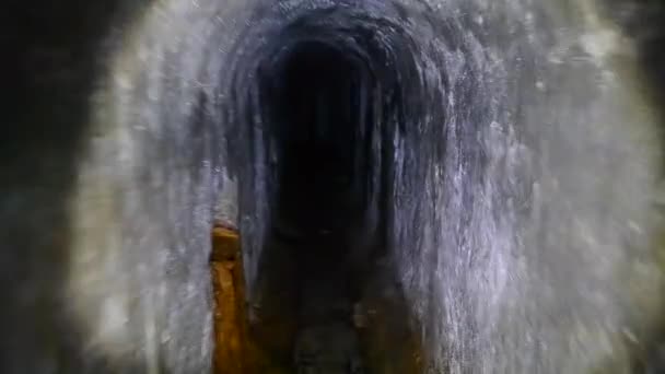暗いトンネルアジット レインコレクター 下水道トンネルを通り抜け ランタンの懐中電灯の光で照らします 地下鉄のインフラストラクチャーが使われています ソーセージコレクター — ストック動画