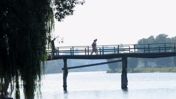 Lidé Muž Kole Kráčející Starém Dřevěném Mostě Přes Řeku Slunečného — Stock video
