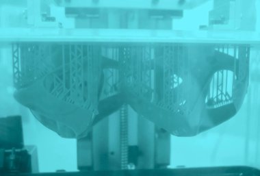 3D yazıcıda yakın plan baskı modelleri. 3D yazıcının içindeki baskı platformunda sıvı fotopolimer reçinelerden fotopolimer sla 3D yazıcıya basılan nesneler. Modern yenilikçi katkı teknolojisi.