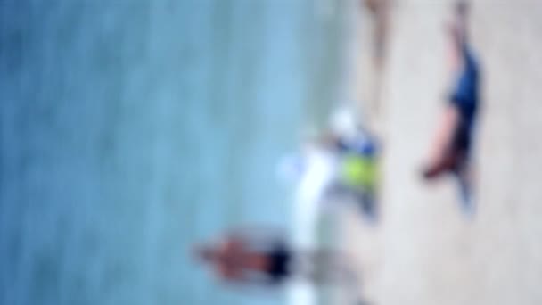 Lidé Odpočívají Opalují Písčité Pláži Klidného Modrého Moře Bílými Bokeh — Stock video