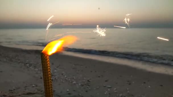 Сжигание Сверкающей Праздничной Свечи Искрами Песке Песчаном Берегу Моря Фоне — стоковое видео