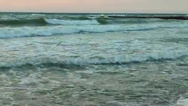 ストーミー海 日没と夜明けの背景に海に白い泡が付いている大きな波 オレンジ色の赤い空と太陽の青い海 海岸沿いの海岸沿いの海岸線 — ストック動画