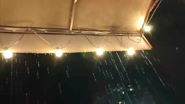 Aliran Hujan Menetes Dari Atap Dengan Lentera Bercahaya Malam Hari — Stok Video
