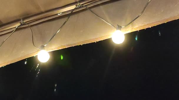 Regenströme Tropfen Nachts Von Einem Dach Mit Leuchtenden Laternen Ströme — Stockvideo