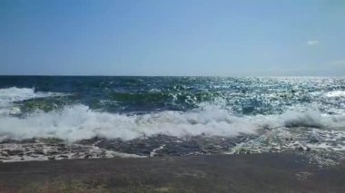 Fırtınalı deniz. Büyük deniz dalgaları güneşli yaz gününde eski beton iskeleye çarpıp çarpıyor. Beyaz köpüklü yüksek dalgalar. Büyük dalgalar kopuyor, çimento iskelesine yayılıyor. Patlamalar ve sıçramalar.