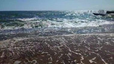 Fırtınalı deniz. Büyük deniz dalgaları güneşli yaz gününde eski beton iskeleye çarpıp çarpıyor. Beyaz köpüklü yüksek dalgalar. Büyük dalgalar kopuyor, çimento iskelesine yayılıyor. Patlamalar ve sıçramalar.