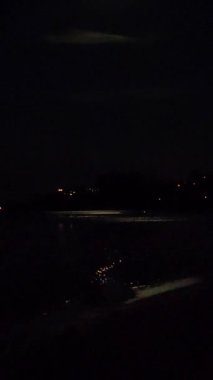 Deniz dalgaları üzerinde ay ışığı yolu gece deniz kıyısı sahillerinde. Gece su yüzeyindeki ay yolu. Su yüzeyinde ay ışığı parlıyor. Doğal arka plan. Doğa Arkaplanı Dikey