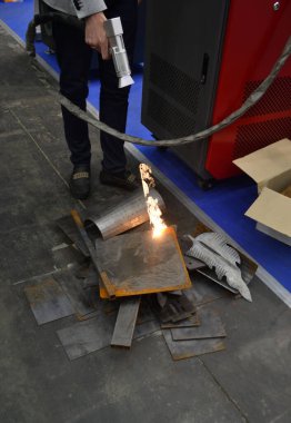 Lazer metal temizliği. Metal bir yüzeyi pasdan temizlemek için lazer metal temizleme makinesi kullanan bir adam. İşçi lazerle metal kaplamasını temizliyor. Çelik lazer temiz teknolojileri. Yeni modern teknoloji