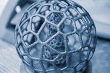 Polyamide tozunun 3 boyutlu yazıcısına yakın planda basılmış, ağ topunda soyut bir Noel ağacı. Teknoloji Multi Jet Füzyonu, MJF. Pudra plastiğinden 3 boyutlu yazıcı üzerinde oluşturulan üç boyutlu model