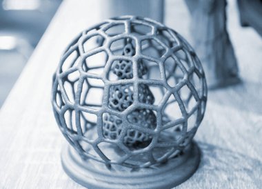 Polyamide tozunun 3 boyutlu yazıcısına yakın planda basılmış, ağ topunda soyut bir Noel ağacı. Teknoloji Multi Jet Füzyonu, MJF. Pudra plastiğinden 3 boyutlu yazıcı üzerinde oluşturulan üç boyutlu model