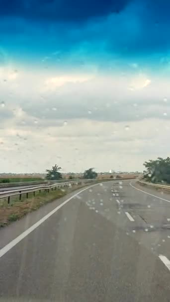 車を運転しながら雨が降るウインドシールドを通る道路の景色 雨天時にトラックを移動するアスファルト多車道のフロントガラスを表示します コンセプト輸送移動 — ストック動画