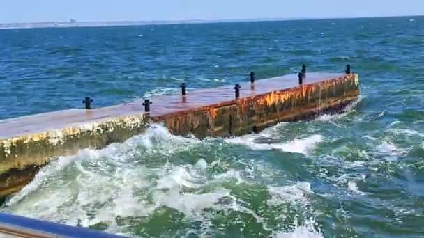 ストーミー海 大きな海の波が衝突し 晴れた夏の日に古いコンクリートの桟橋に当たります 白い泡の高い波 大きな波が壊れ セメントの桟橋に広がりました スプラッシュバーストとスプラッシュ — ストック動画