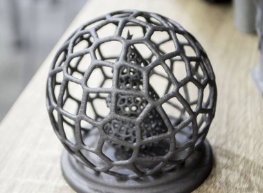 Polyamide tozunun 3 boyutlu yazıcısına yakın planda basılmış, ağ topunda soyut bir Noel ağacı. Teknoloji Multi Jet Füzyonu, MJF. Pudra plastiğinden 3 boyutlu yazıcı üzerinde oluşturulan üç boyutlu model