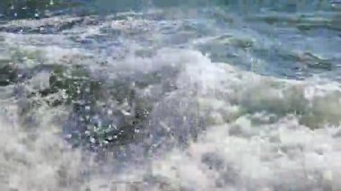 Büyük dalgalar eski çimento kıyısına çarpıyor. Güneşli bir günde dalgalar iskele iskelesine vuruyor. Fırtına, fırtınalı deniz. Hava durumu. Beyaz köpüklü yüksek dalgalar.