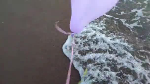 Kleurrijke Opblaasbare Ballen Achtergrond Van Zee Tijdens Sterke Wind Persoon — Stockvideo