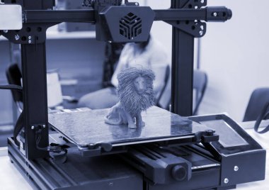 3 boyutlu yazıcıya basılmış oyuncak aslan modeli 3D yazıcının masaüstündeki erimiş plastiğin mavi renginden. Konsept 3D yazıcı, 3D yazıcı, modelleme üç boyutlu nesne. Yenilikçi üretim
