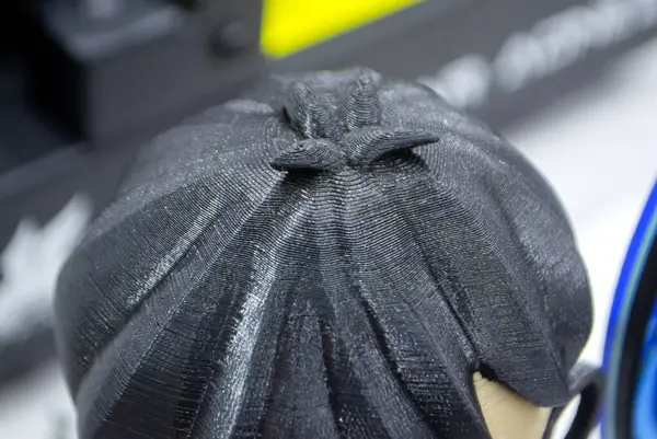 Prototype of head with black hair 3D printed from melted plastic. Close-up model of toy created on 3D printer. New innovation modern 3D printing technologies. Additive progressive technology. 3D model