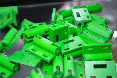 Birçok yeşil detay 3D yazıcıya yakın planda basıldı. Erimiş plastikten üç boyutlu parçalar. FDM teknolojileri. Katkı sağlayan yenilikçi modern teknoloji. 3D baskı teknolojisi. Yenilik prototipi