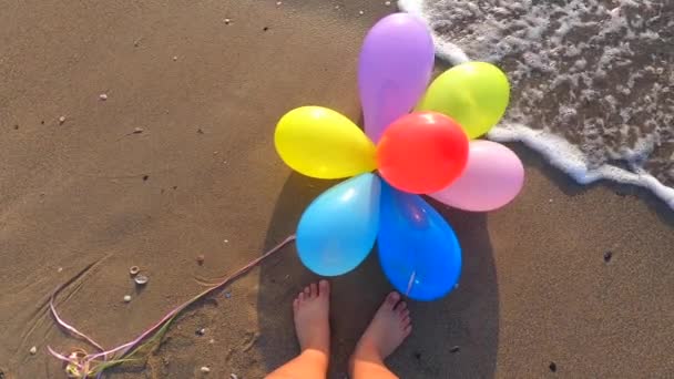 Ένα Μάτσο Πολύχρωμα Μπαλόνια Ξαπλωμένα Στην Υγρή Άμμο Της Παραλίας — Αρχείο Βίντεο