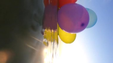 Güneşli bir yaz gününde bir grup renkli balon denizin dalgalarında salınır. Birçok renkli küçük balonlar birbirine bağlanmış olarak sabahları suyun yüzeyinde yüzerler.