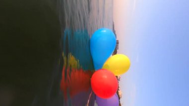 Bir grup havadar renkli balon güneşli yaz günlerinde evleri ve binaları olan kıyı şeridi yakınlarındaki deniz dalgalarında salınırlar. Birçok renkli küçük balonlar birbirine bağlı yüzeyde dikey yüzerler.