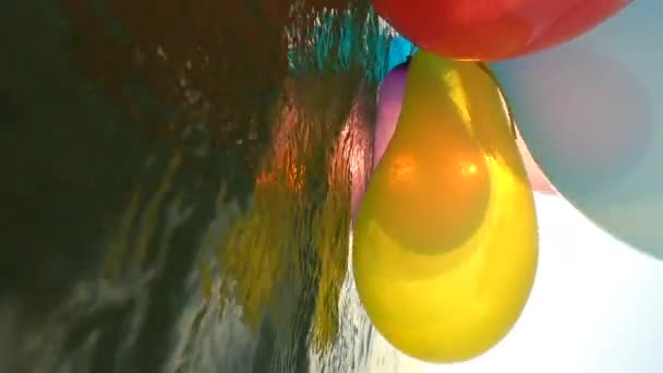 Ett Gäng Luftiga Flerfärgade Ballonger Svingar Havets Vågor Soliga Sommardagar — Stockvideo