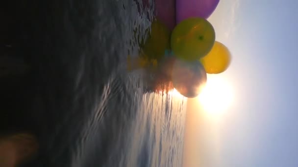 Stelletje Luchtige Meerkleurige Ballonnen Zwaaien Golven Van Zee Een Zonnige — Stockvideo