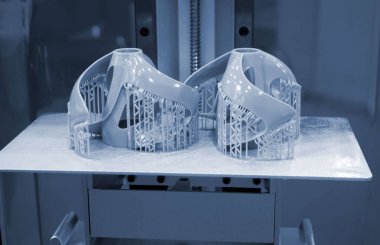 3D yazıcıda yakın plan baskı modelleri. 3D yazıcının içindeki baskı platformunda sıvı fotopolimer reçinelerden fotopolimer sla 3D yazıcıya basılan nesneler. Modern yenilikçi katkı teknolojisi.