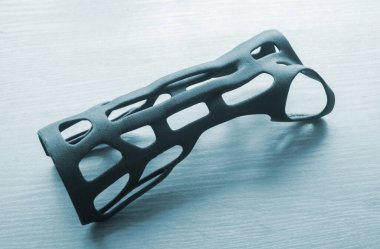 Elle sabitlenmiş korse protez landalı erimiş plastikten üç boyutlu bir yazıcıya basılmış. Tıbbi ortoz, fiksatör, 3D yazıcıda oluşturulan plastik kaplama. Yeni modern tıbbi 3D baskı teknolojileri