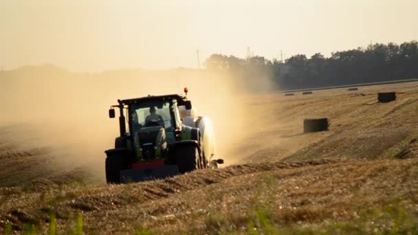 2023年8月19日 ウクライナのタセルナ フィールドからベール駆動場にストローを押すコンバインハーベスター 晴れた夏の夕方 押された小麦のバレルでフィールド フィールドにたくさんの塵 農業について — ストック動画