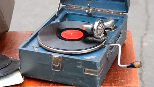在跳蚤市场用老式留声机播放旧的复古唱片 便携式留声机的工作 老式的破旧的唱片乙烯播放器 留声机 波特芬 怀旧风格 — 图库视频影像