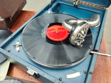 Bit pazarında eski moda gramofonda çalan eski bir retro plak. Taşınabilir gramofon işi. Eski, pejmürde bir plak çalar, fonograf, potefon. İğne. Nostalji antika ses döner tablosu