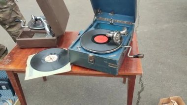 Bit pazarında eski moda gramofonda çalan eski bir plak plağı. Taşınabilir gramofon işi. Eski, pejmürde, pis bir plak çalar, fonograf, potefon. Nostalji antika ses döner tablosu