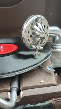 Bit pazarında antika gramofonda çalan eski bir retro plak. Taşınabilir gramofon işi. Eski püskü bir plak çalar, fonograf, potefon. İğneyi yakın tut. Nostaljik antika turntable. Dikey